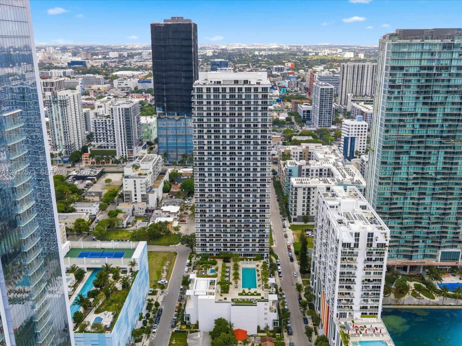 An aerial view shows multiple high-rise apartment buildings and urban streets in a city — 600 NE 27th St, Miami FL 33137, MIAMI, FL