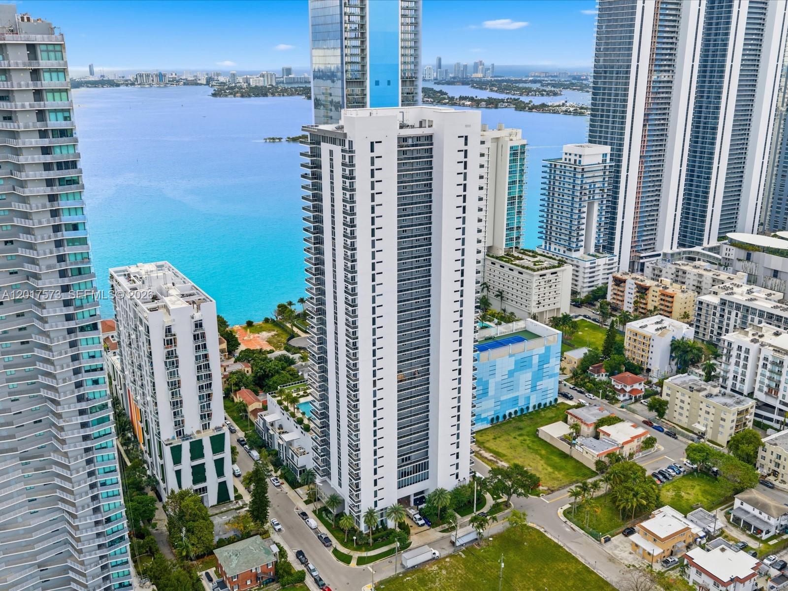 An aerial view shows a tall white residential tower surrounded by other high-rise buildings — 600 NE 27th St, Miami FL 33137, MIAMI, FL