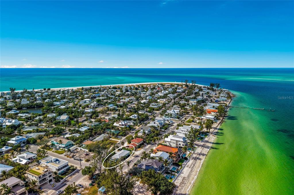 An aerial view shows a coastal neighborhood with a single-story house circled in white — 912 N SHORE DRIVE, ANNA MARIA, FL