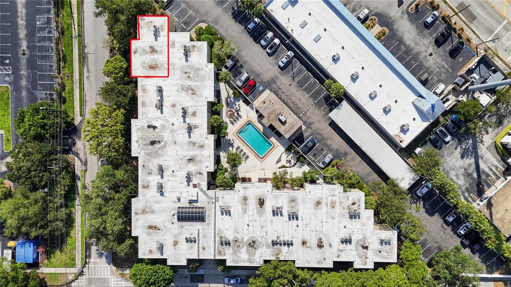 This aerial view shows a multi-story building with a flat roof and a swimming pool — 2302 S MANHATTAN AVENUE UNIT 214, TAMPA, FL