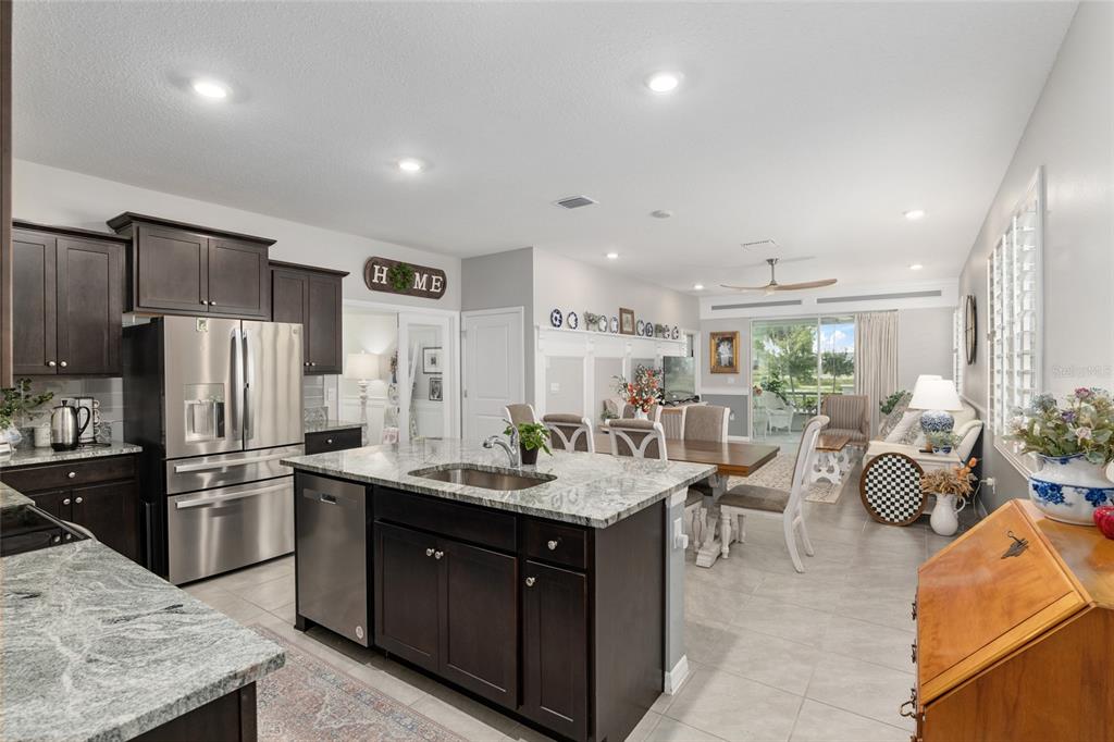An entryway with tile flooring, gray walls, white trim, and a view into a bedroom — 5089 STOKES WAY, WILDWOOD, FL