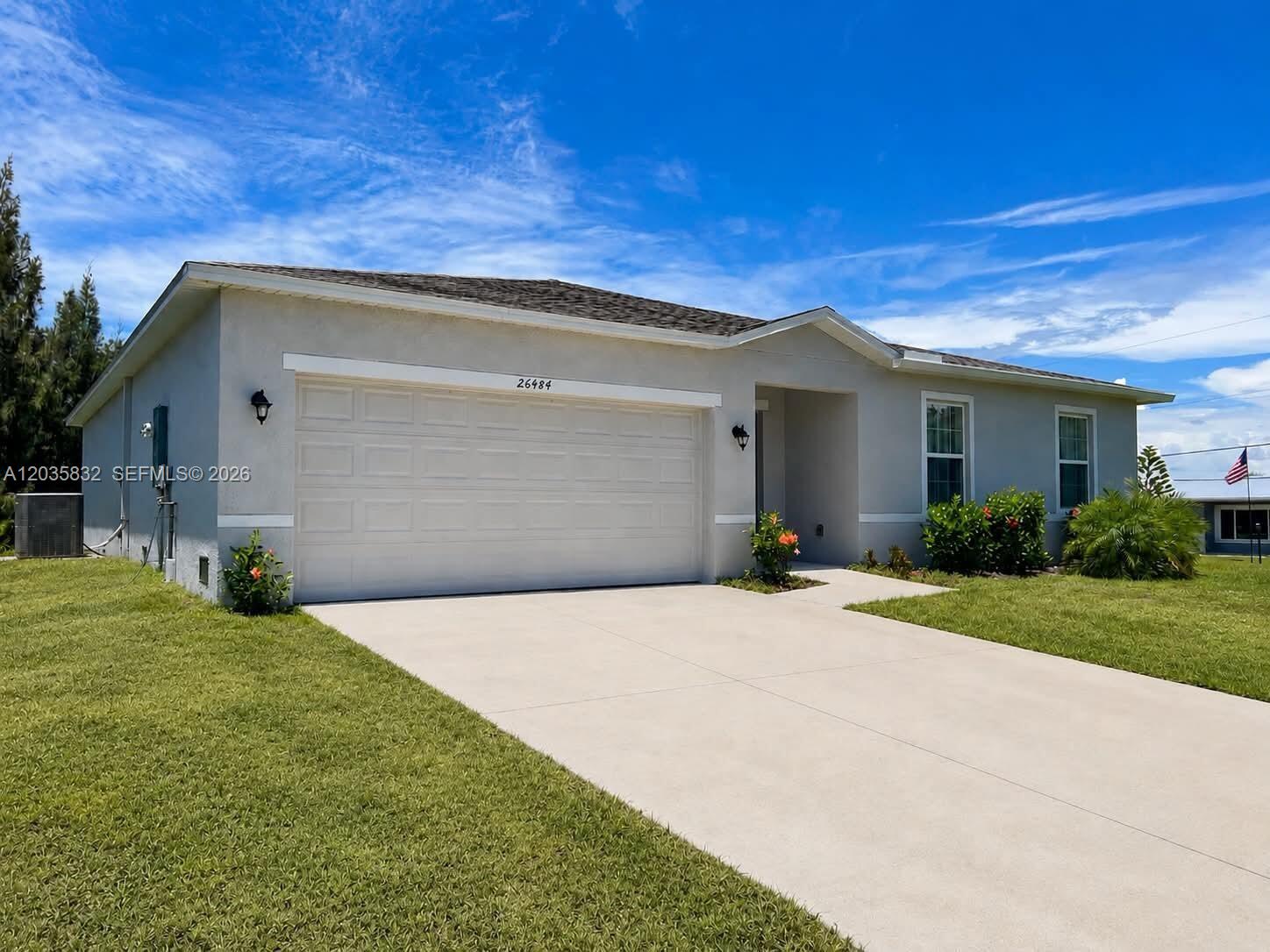 A single-story house with a concrete driveway, a two-car garage, and a small front lawn — 26484 View Dr, Punta Gorda FL 33983, PUNTA GORDA, FL