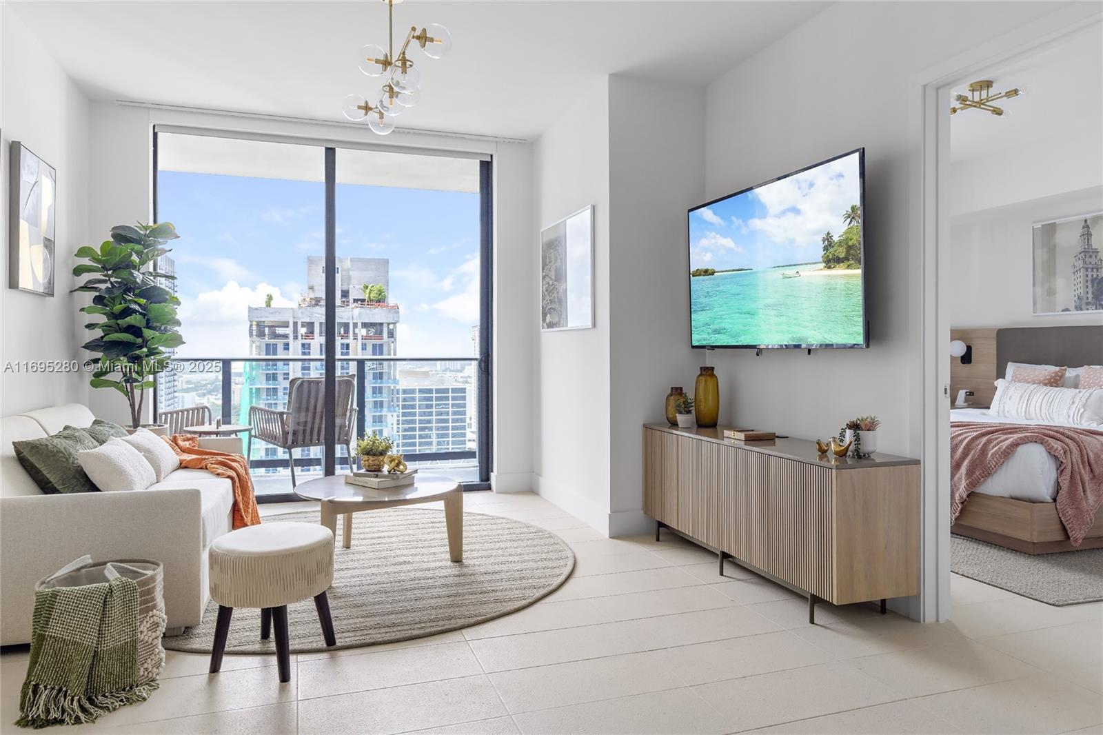 A modern living room with a wall-mounted television, neutral furniture, and a balcony view — 159 NE 6TH ST # 2704, Miami FL 33132, MIAMI, FL