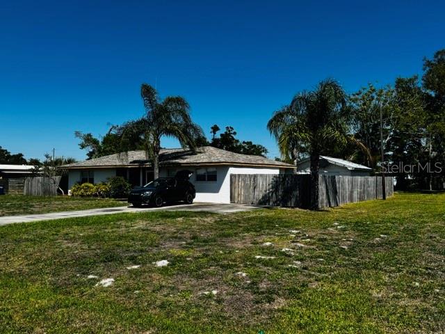 A single-story house with a wooden fence and a car parked in the driveway — 308 LINDEN DRIVE, ELLENTON, FL