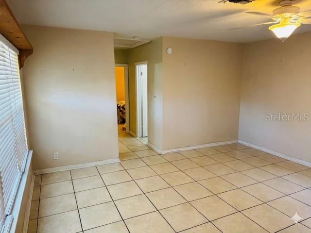 An empty room features beige walls, light-colored tile flooring, and a ceiling fan — 308 LINDEN DRIVE, ELLENTON, FL