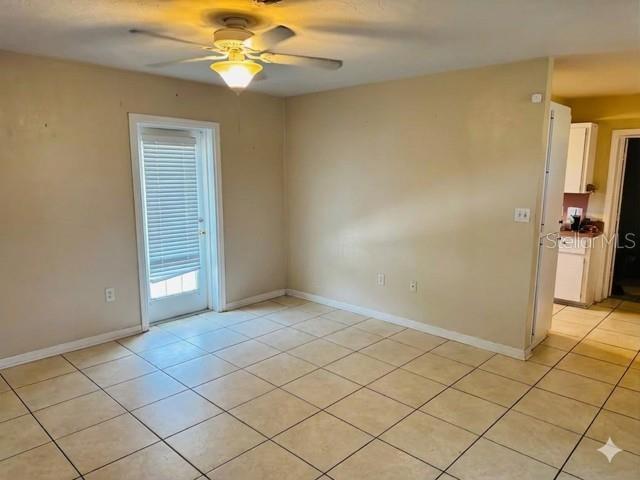 A room with beige walls, tiled floors, a ceiling fan, and a glass-paned door — 308 LINDEN DRIVE, ELLENTON, FL