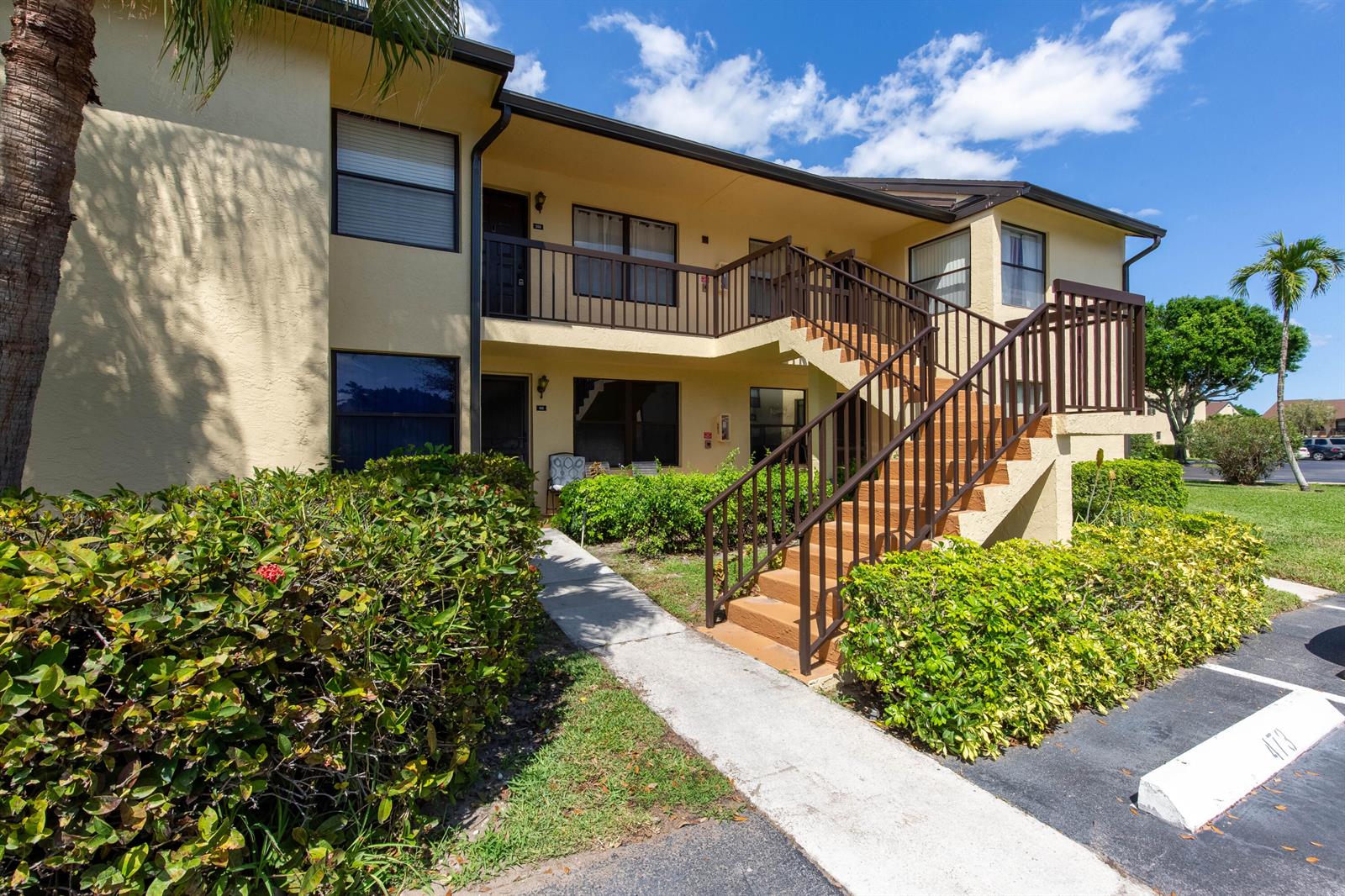 An exterior view of a two-story apartment building with a staircase leading to the second floor — 4715 Lucerne Lakes Boulevard E # 205, FL 33467, FL