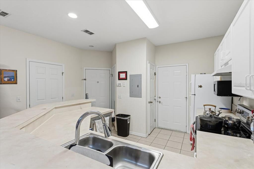 A kitchen features a double-basin sink, white cabinets, a black stove, and tiled flooring — 13200 W NEWBERRY ROAD UNIT 86, NEWBERRY, FL