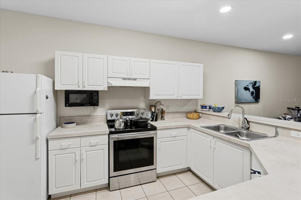 A kitchen featuring white cabinets, stainless steel appliances, and light-colored countertops — 13200 W NEWBERRY ROAD UNIT 86, NEWBERRY, FL