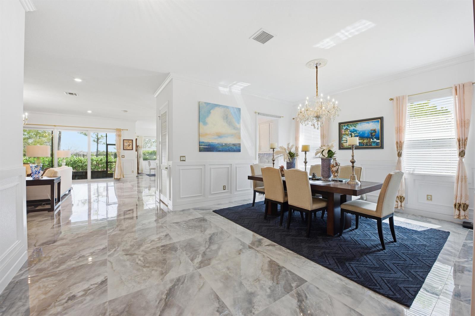 A dining room with a dark rug, marble floors, and a crystal chandelier — 984 Sterling Pine Place, Loxahatchee FL 33470, LOXAHATCHEE, FL