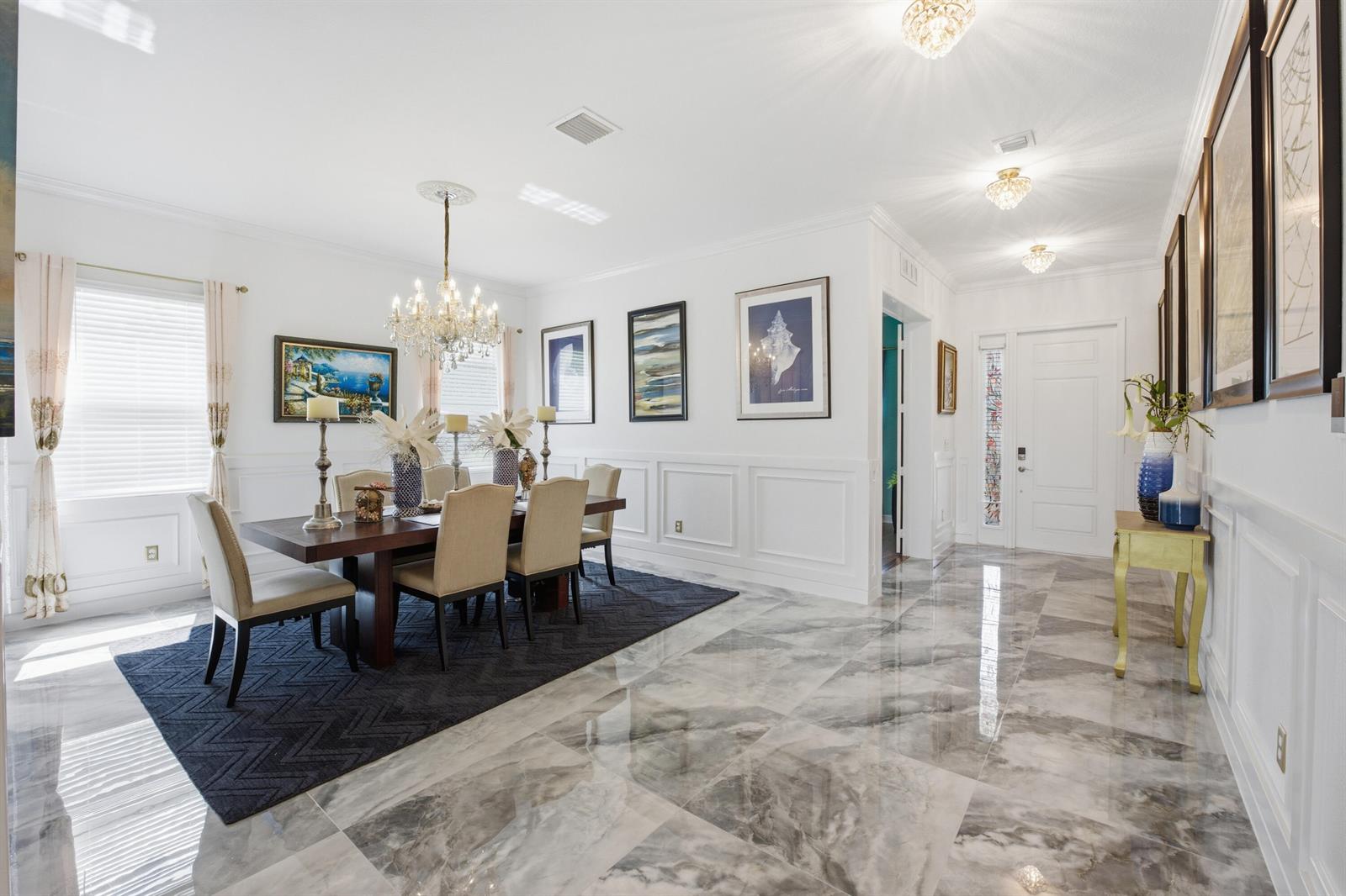 A dining room with a dark wood table, beige chairs, and marble flooring — 984 Sterling Pine Place, Loxahatchee FL 33470, LOXAHATCHEE, FL