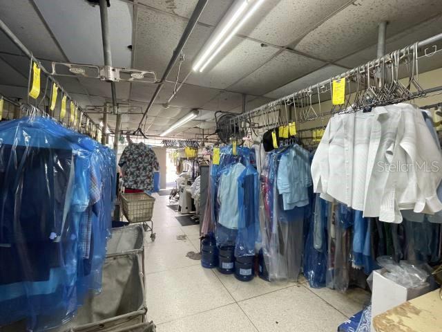 A commercial dry cleaning facility features rows of hanging garments protected by plastic covers — 400 AV. ING. MANUEL DOMENECH, SAN JUAN, PR