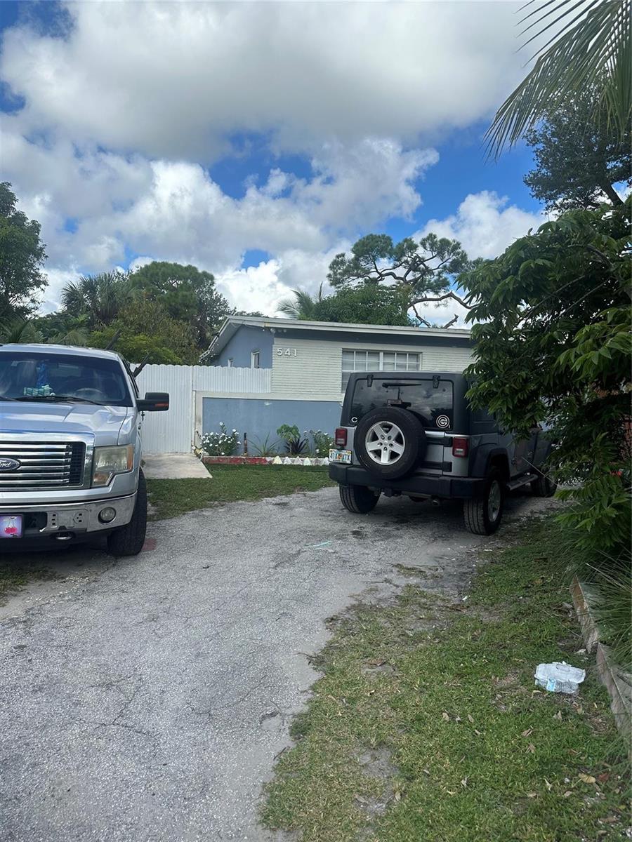A silver pickup truck and a gray Jeep are parked in a gravel driveway — 541 NW 33rd Avenue, Lauderhill FL 33311, LAUDERHILL, FL