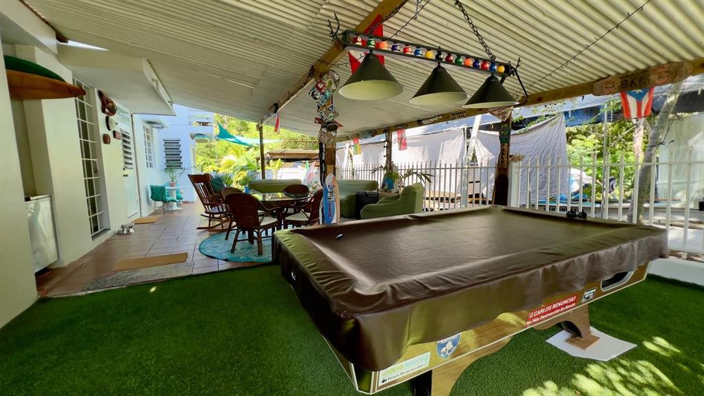 A covered outdoor patio features a pool table, wicker furniture, and artificial turf flooring — Calle #2 URB VISTA AZUL UNIT C-22, RINCON, PR