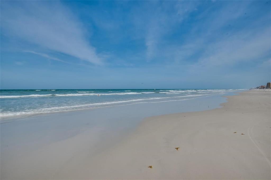 A wide, sandy beach meets the ocean under a blue sky with light clouds — 5300 S ATLANTIC AVENUE UNIT 6-502, NEW SMYRNA BEACH, FL
