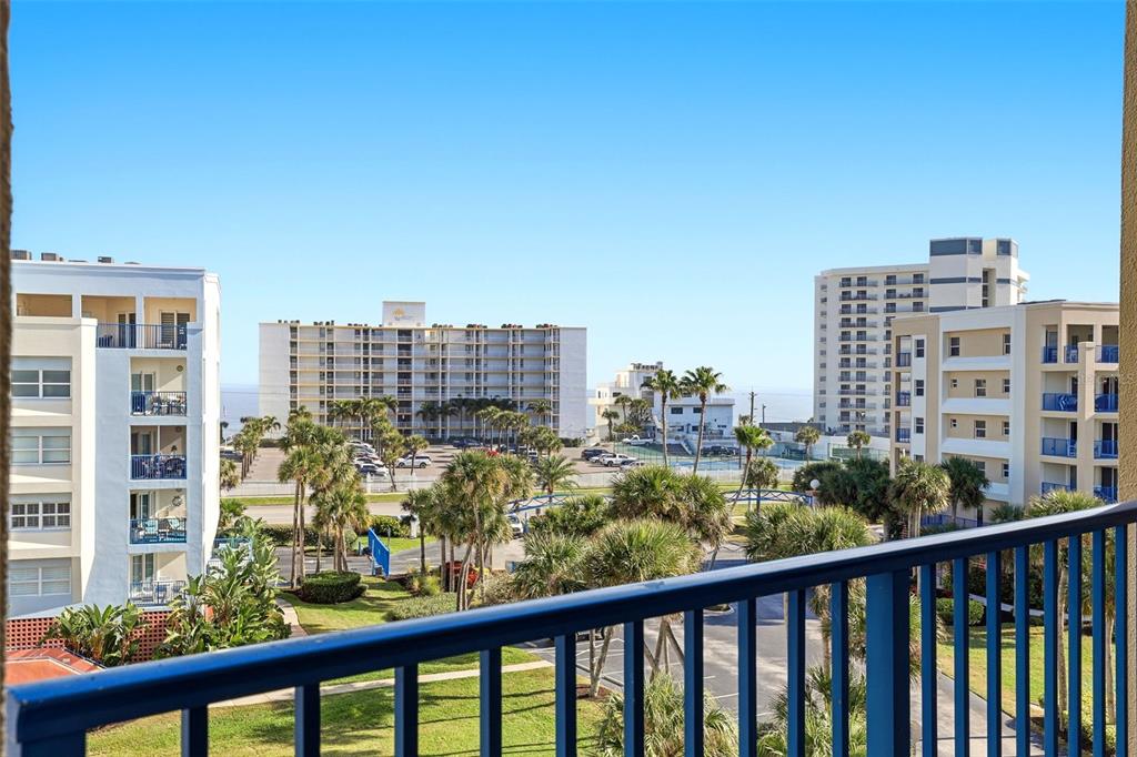 An aerial view shows a community swimming pool surrounded by a patio, lounge chairs, and buildings — 5300 S ATLANTIC AVENUE UNIT 6-502, NEW SMYRNA BEACH, FL