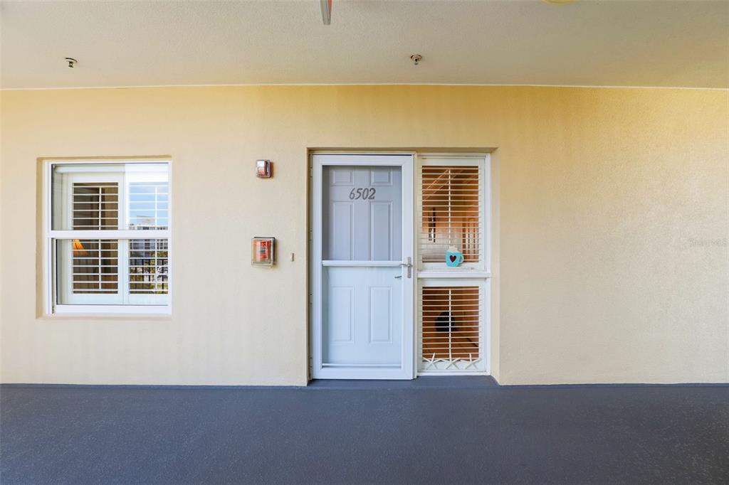 A dining area with a glass table and white chairs sits adjacent to a kitchen — 5300 S ATLANTIC AVENUE UNIT 6-502, NEW SMYRNA BEACH, FL