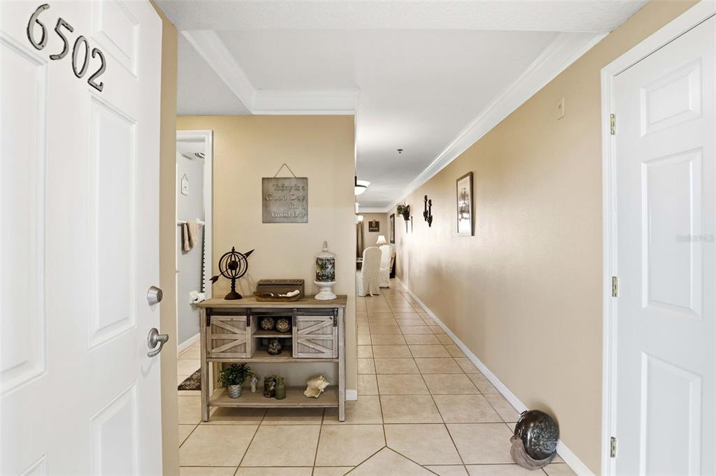 A sunroom with tile flooring, a ceiling fan, and large windows overlooking a wooded area — 5300 S ATLANTIC AVENUE UNIT 6-502, NEW SMYRNA BEACH, FL