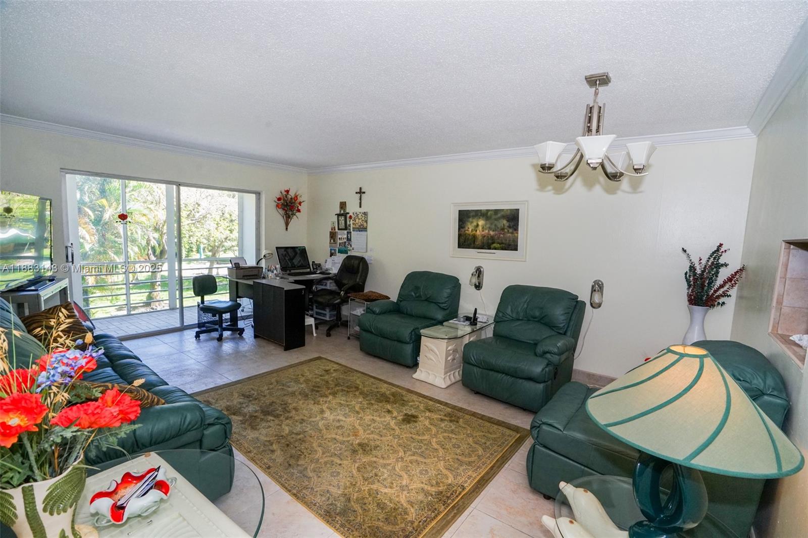 A living room features green leather furniture, a patterned area rug, and a home office area — 1000 NE 14th Ave # 207, Hallandale Beach FL 33009, HALLANDALE BEACH, FL