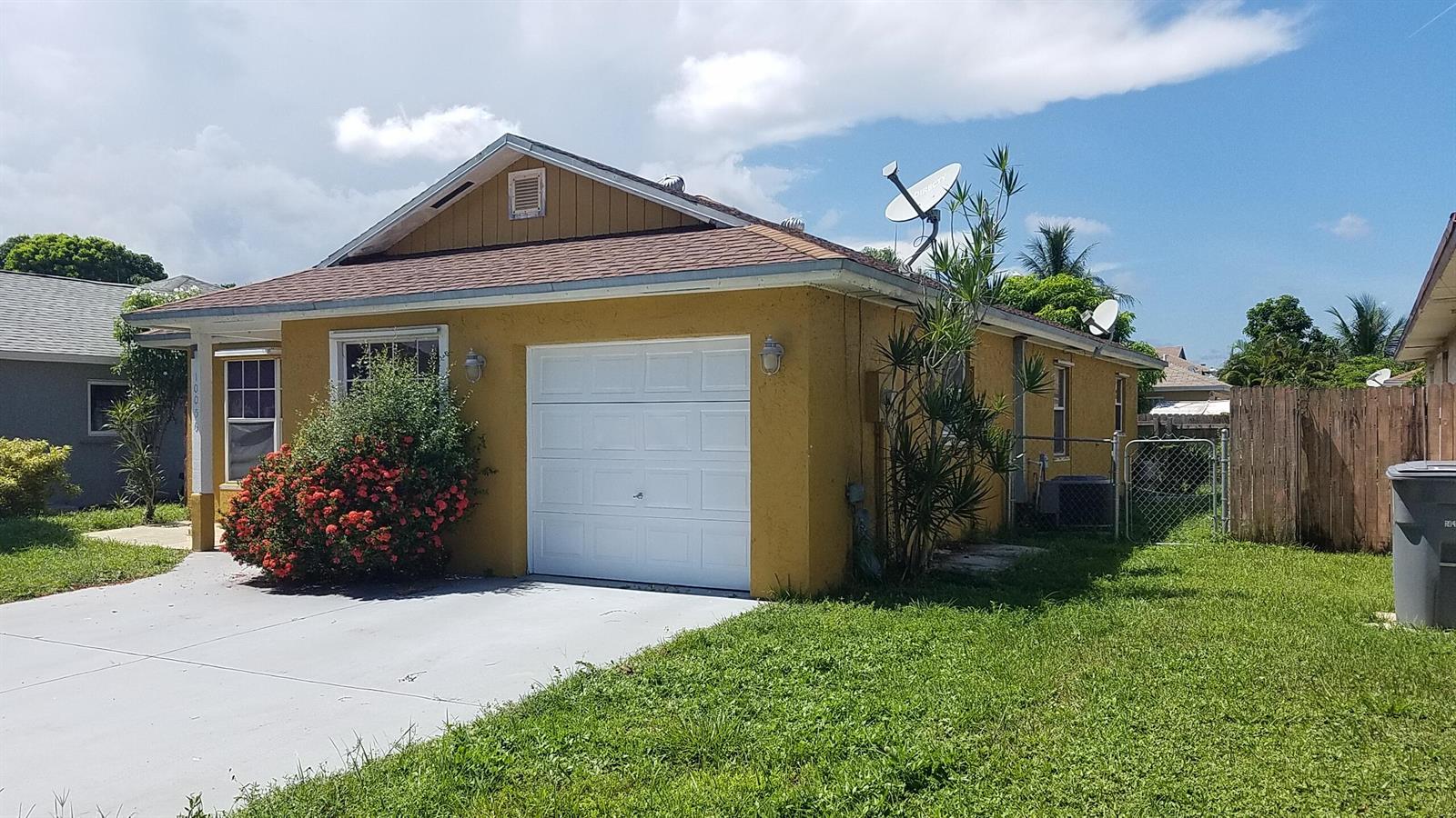 A yellow single-story house with a white garage door and a satellite dish on the roof — 10056 Boynton Place Circle, Boynton Beach FL 33437, BOYNTON BEACH, FL