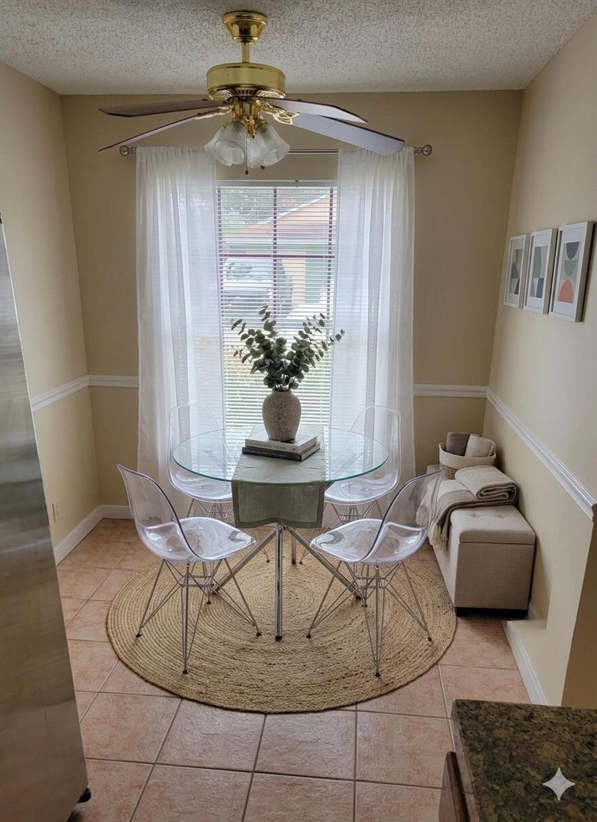 A small dining nook features a glass table, four clear chairs, and a round rug — 10056 Boynton Place Circle, Boynton Beach FL 33437, BOYNTON BEACH, FL
