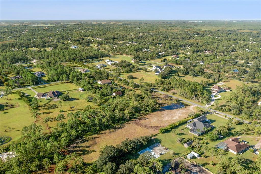 An aerial view shows a rural residential area with scattered houses, trees, and open fields — BABBITT AVENUE, ORLANDO, FL