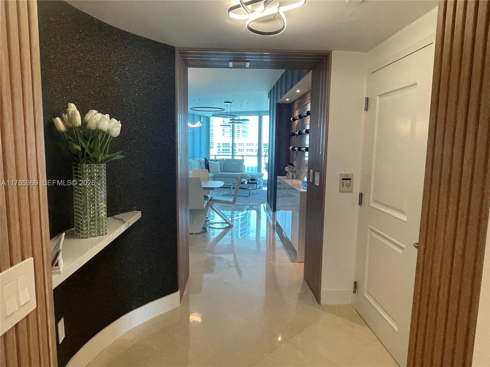 A modern entryway leads into a bright living area with white tile floors and decor — 3101 S Ocean Dr # 1707, Hollywood FL 33019, HOLLYWOOD, FL