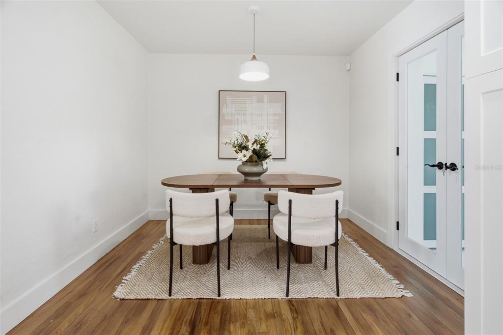 A dining room features a wooden table, four white chairs, and a textured area rug — 832 THALIA DRIVE, ORLANDO, FL