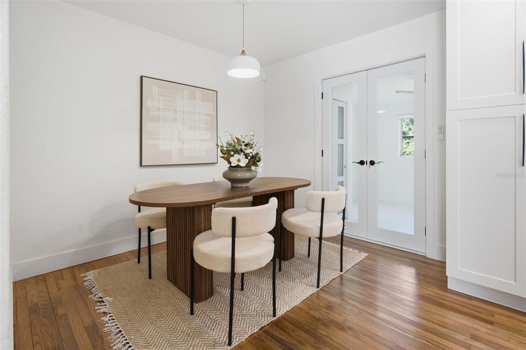 A dining room features a wooden oval table, cream chairs, and a textured area rug — 832 THALIA DRIVE, ORLANDO, FL