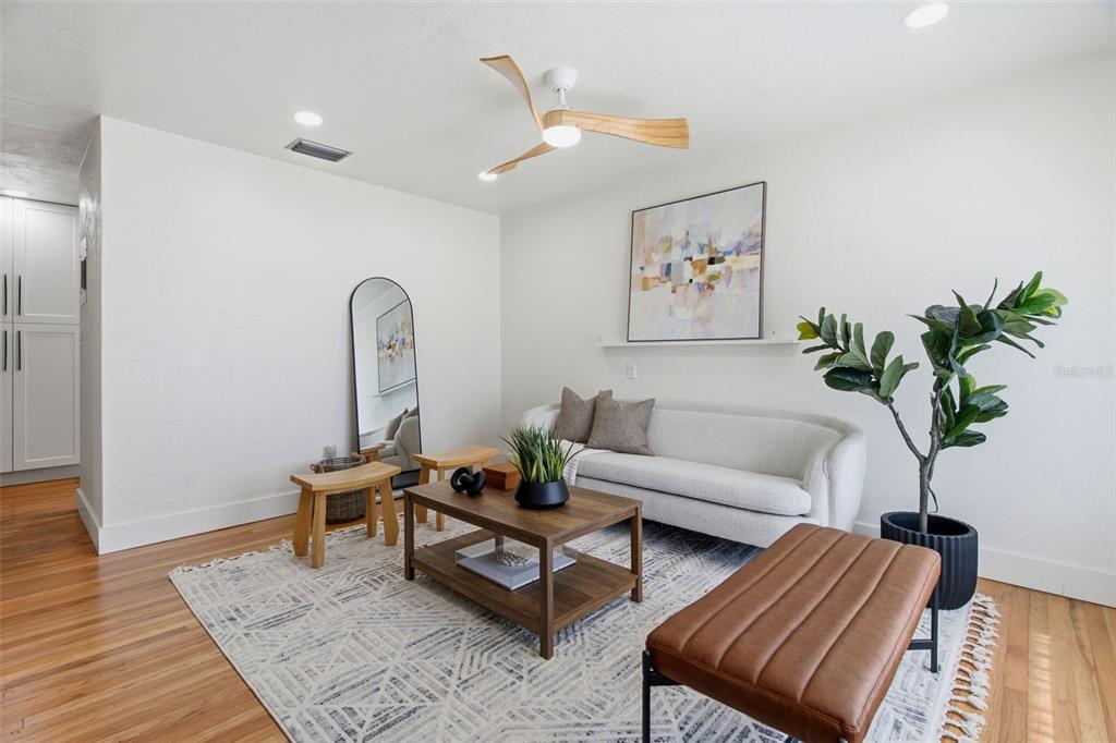 A living room features a white sofa, wooden coffee table, leather bench, and ceiling fan — 832 THALIA DRIVE, ORLANDO, FL