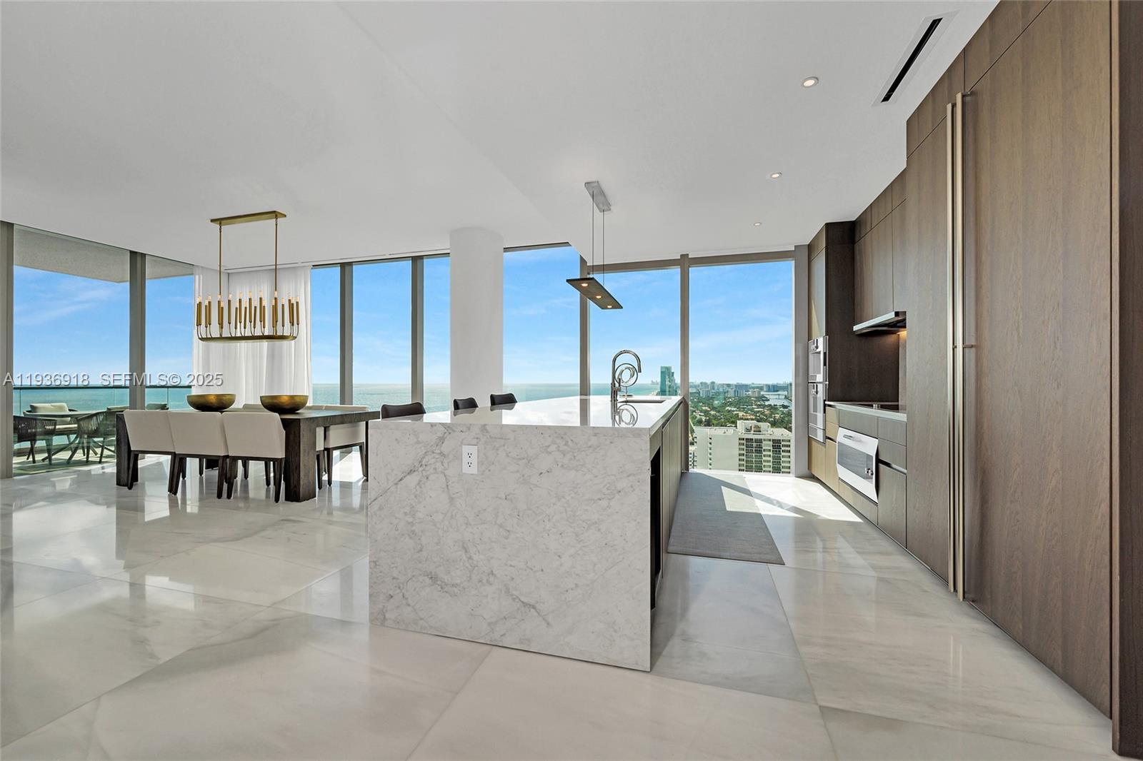 A modern kitchen and dining area feature marble floors, a stone island, and ocean views — 2000 S Ocean Dr # 30B, Hallandale Beach FL 33009, HALLANDALE BEACH, FL