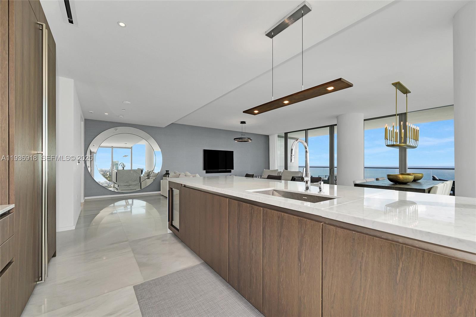 A modern kitchen features a large island with a marble countertop and wood cabinetry — 2000 S Ocean Dr # 30B, Hallandale Beach FL 33009, HALLANDALE BEACH, FL