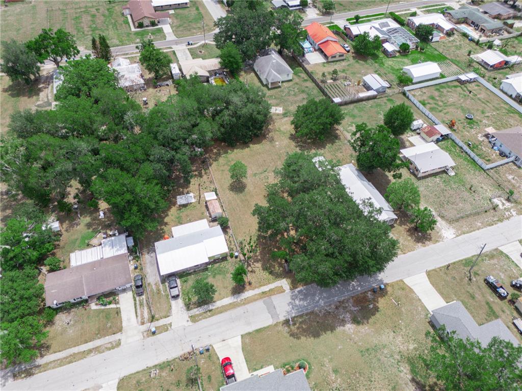 An aerial view shows a vacant residential lot surrounded by trees and neighboring houses — 0 S PERRY AVENUE, FORT MEADE, FL