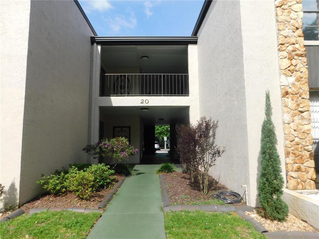 A walkway leads to the entrance of a two-story building with a stone facade section — 20 S ROSE AVENUE, KISSIMMEE, FL