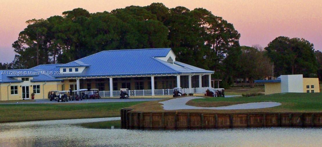 A clubhouse with a blue metal roof sits beside a pond and golf course — 6451 San Bruno Drive, Sebring FL 33872, SEBRING, FL
