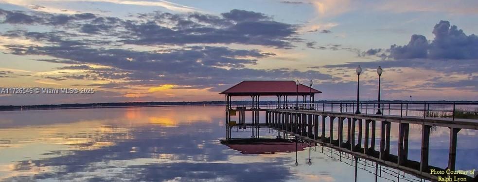 A long pier with a covered pavilion extends into a calm lake at sunset — 6451 San Bruno Drive, Sebring FL 33872, SEBRING, FL