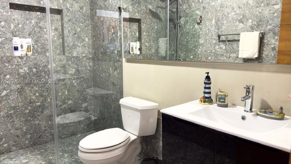 A bathroom features a glass-enclosed shower, gray terrazzo-style tile walls, and a white vanity — 0 Punta Cana village # 0, FL, FL