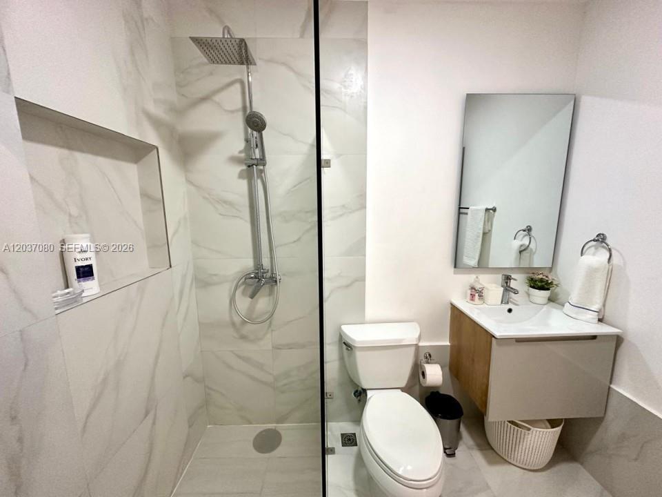 A modern bathroom features a glass-enclosed shower, a white toilet, and a floating vanity — 0 Punta Cana village # 0, FL, FL