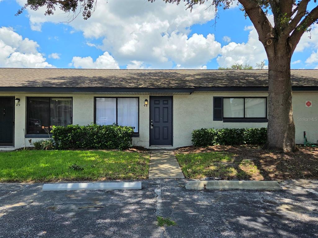 A single-story residential building exterior features a dark front door, windows, and a paved walkway — 605 NORTHLAKE BOULEVARD UNIT 48, ALTAMONTE SPRINGS, FL