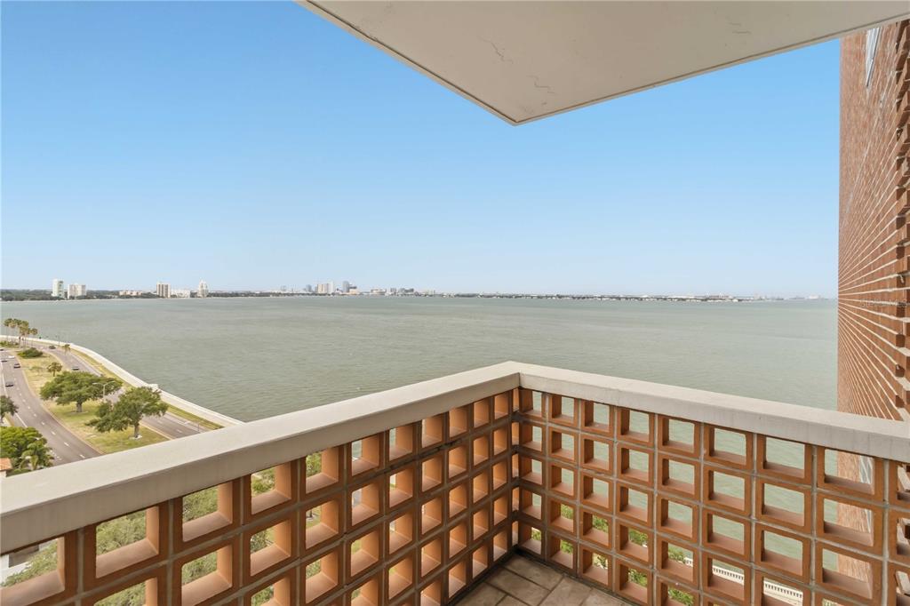 A balcony with a brick lattice railing overlooks a large body of water and coastline — 4015 BAYSHORE BOULEVARD UNIT 12B, TAMPA, FL