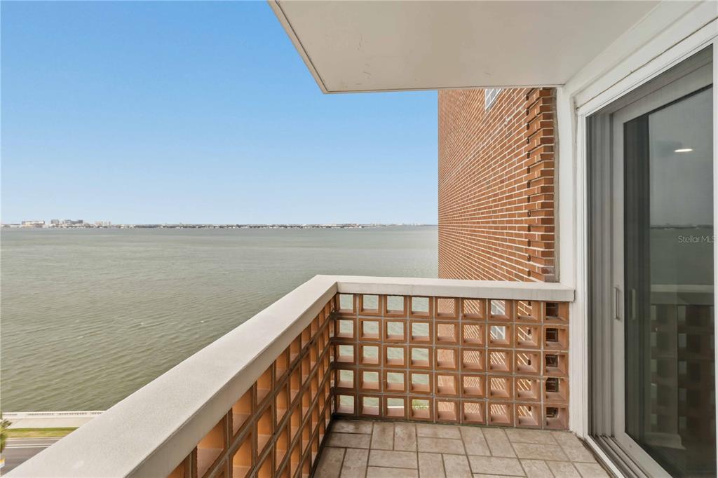 A balcony with a tiled floor and a decorative brick screen overlooks a large body of water — 4015 BAYSHORE BOULEVARD UNIT 12B, TAMPA, FL