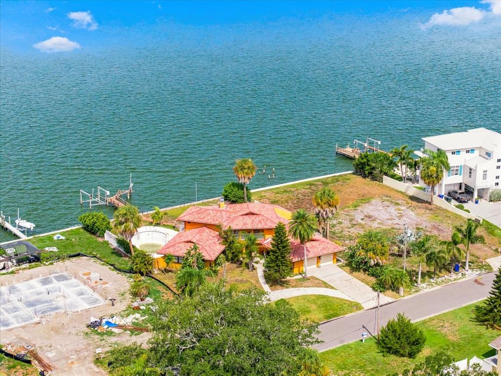 An aerial view of a waterfront house with a red tile roof and swimming pool — 111 SHORE DRIVE, DUNEDIN, FL