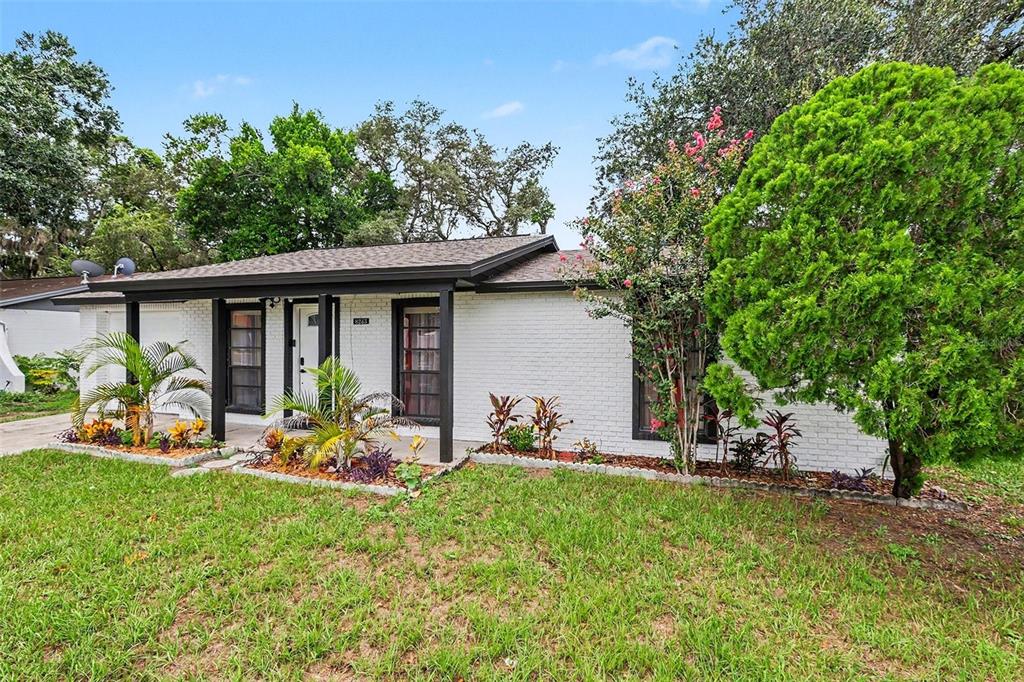 A single-story white brick house with black trim and a front porch — 8253 GREENLEAF CIRCLE, TAMPA, FL