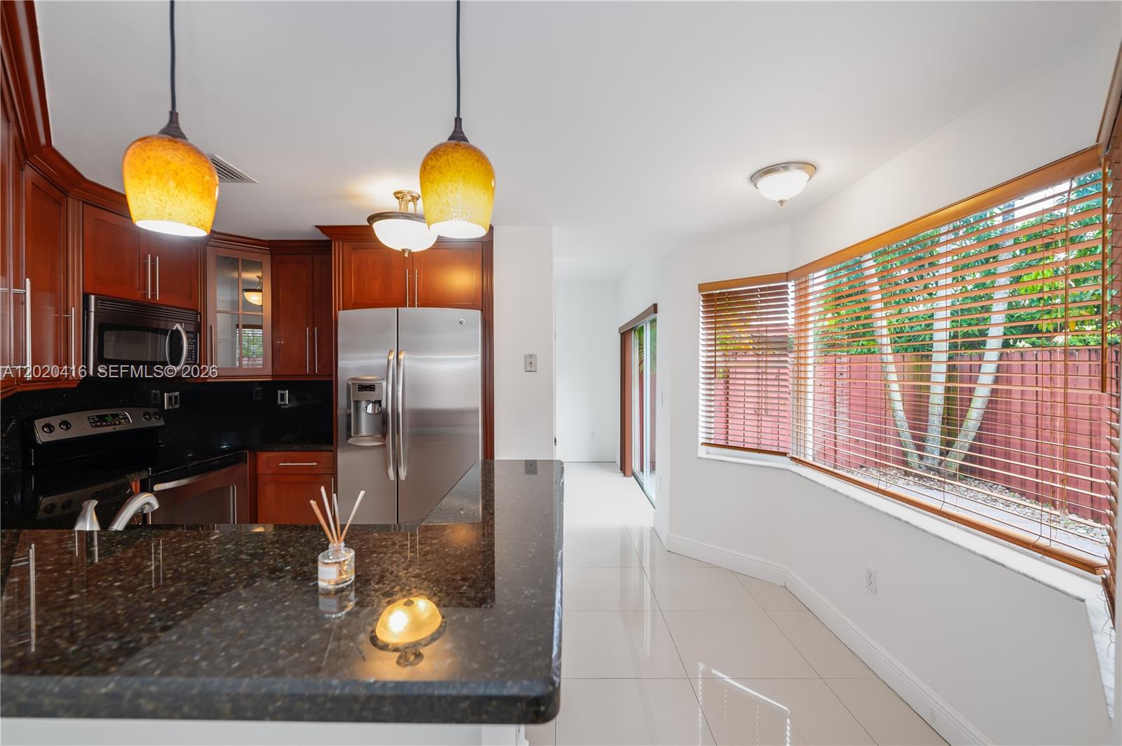 A kitchen with dark wood cabinets, granite countertops, stainless steel appliances, and a bay window — 4668 SW 153rd Ct, Miami FL 33185, MIAMI, FL