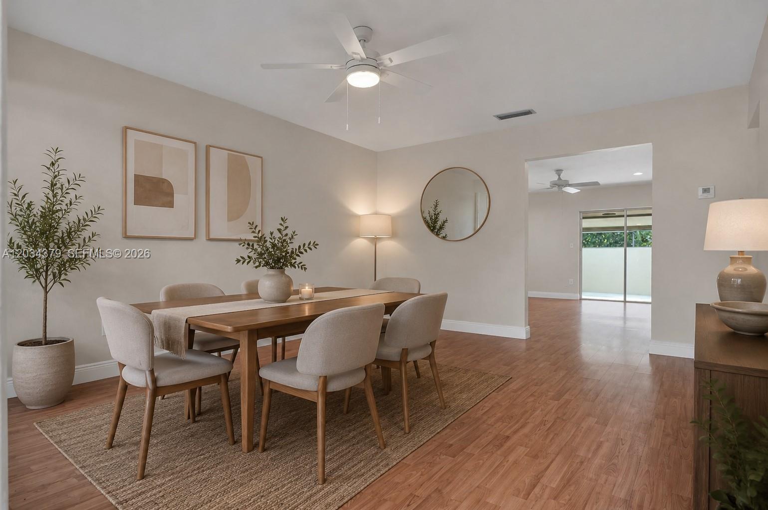 A dining room features a wooden table, upholstered chairs, a ceiling fan, and hardwood flooring — 10953 SW 122nd Ct, Miami FL 33186, MIAMI, FL