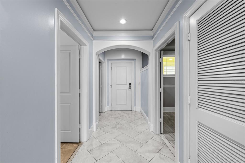 A hallway with light blue walls, white trim, and white tile flooring in a herringbone pattern — 509 W BAY STREET UNIT 305, TAMPA, FL