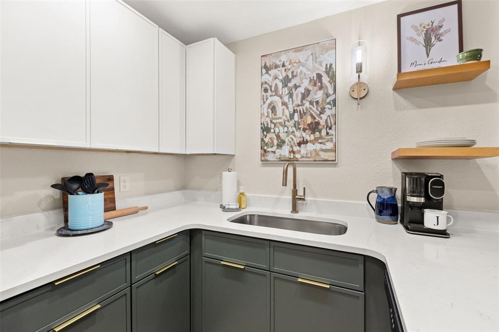 A kitchen features white upper cabinets, dark green lower cabinets, and a stainless steel sink — 1928 CONWAY ROAD UNIT 40, ORLANDO, FL