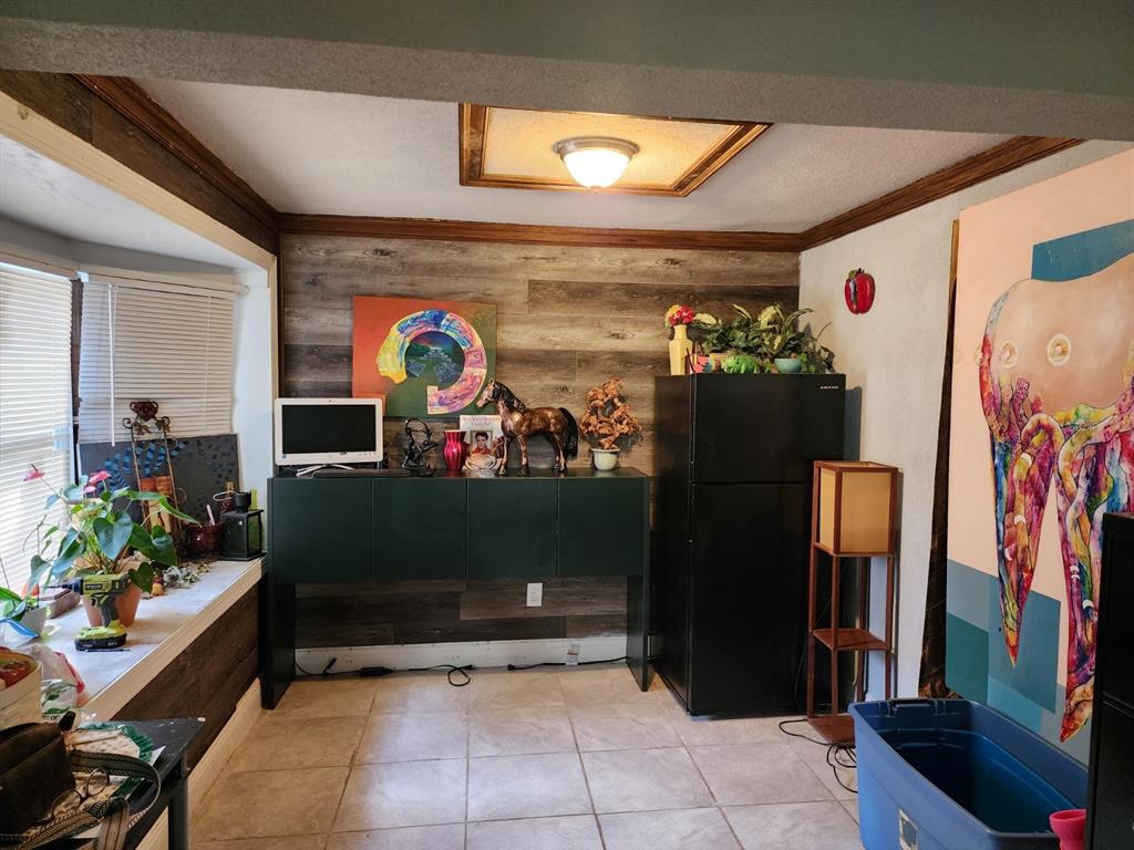 A room with wood-look accent wall, black sideboard, black refrigerator, and large tooth-themed wall art — 1149 HOLDEN AVENUE, ORLANDO, FL