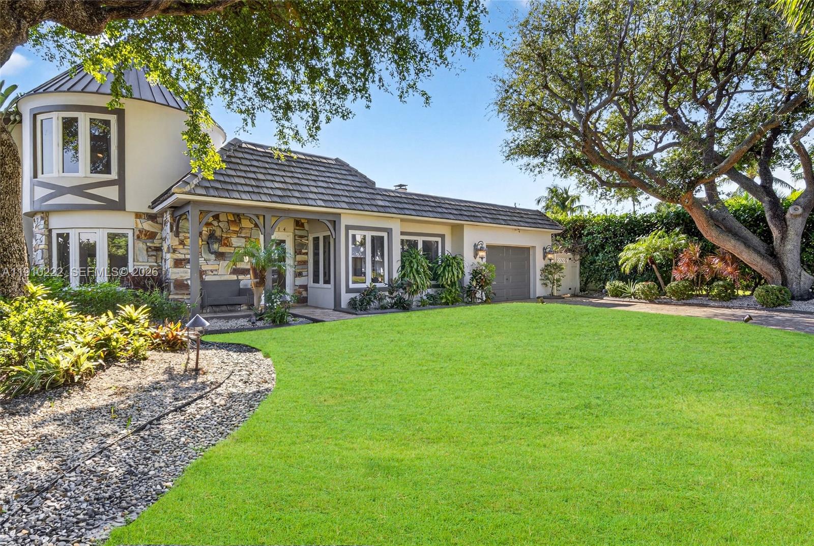 A paved driveway leads toward Mediterranean-style houses surrounded by lush tropical landscaping and palm trees — 3414 Norfolk St, Pompano Beach FL 33062, POMPANO BEACH, FL