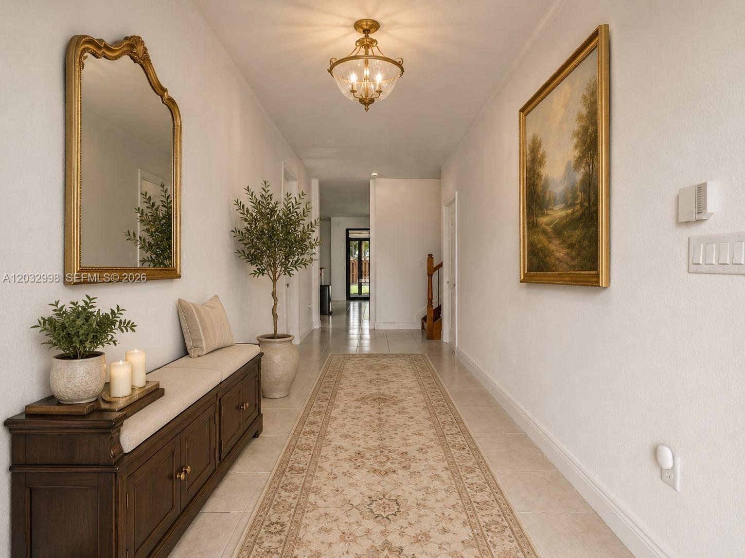 A hallway features a wooden bench, a large mirror, a landscape painting, and a runner rug — 9925 NW 10th St, Miami FL 33172, MIAMI, FL